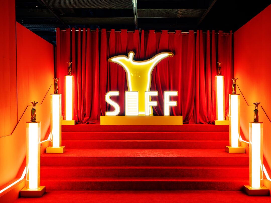 Wide view of a red carpet event with photographers and camera flashes